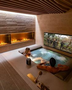 a man and woman in a hot tub with fire coming out of the fireplaces