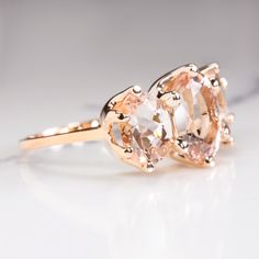 an engagement ring with two stones in it on a white surface, close up view