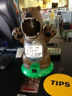 a bear statue with its mouth open on top of a desk next to a computer