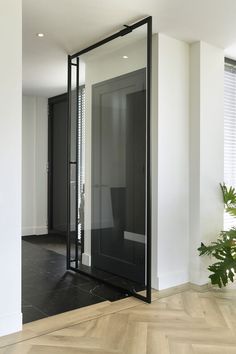 an empty room with a large mirror on the wall next to a potted plant