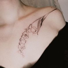 a woman's chest with flowers and leaves tattoo on her left side breast area