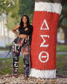 a woman standing next to a large red and white pole with the word ao on it