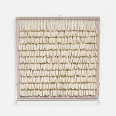 an art piece made out of sticks on a white surface with the top section cut off