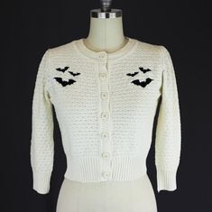 About This Item The Cozy Stretchy Knit Cardigan Features 3/4 Sleeves, A Button Up Closure, And Black Bat Embroidery. Enjoy This Cozy, Light Weight, And Cute Cardigan For Day Time And Night Time! Pair It With Retro Dresses, Skirts, Pants, Capris, And Shorts For Family And Friend Outings! - 80% Acrylic, 18% Nylon, 2% Spandex - Made In The Usa - Hand Wash Cold - Lay Flat To Dry Measurements Are In Inches Size.....Crop Length.....Shoulder......Chest.....Sleeve Length S.................17.5 ......... White Retro Sweater With Buttons, Retro White Sweater With Buttons, White Fitted Button-up Sweater, White Fitted Retro Cardigan, Vintage White Cardigan With Buttons, Vintage White Cardigan With Button Closure, Friend Outings, Bat Sweater, Bat Embroidery