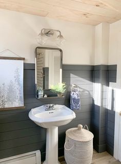 a white sink sitting under a bathroom mirror next to a radiator heater