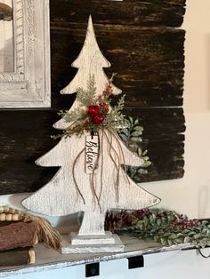 a wooden christmas tree sitting on top of a shelf