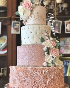 a three tiered wedding cake with flowers on top