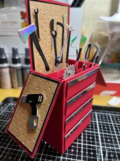 a red tool box with scissors and other tools in it on top of a table