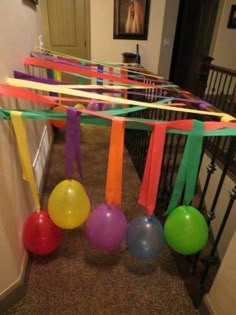 some balloons and streamers are hanging from the ceiling in front of a stairway way