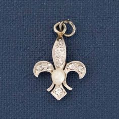 We recently acquired a batch of Deco-era charms that belonged to the same collector with a taste for diamonds, white metal, and yummy gemstone accents. This one is a diamond fleur de lis with a sweet pearl center, the size and spread of which we absolutely adore. Platinum & 18kt yellow gold .71 pennyweight Measures: 16.61 x 11.03mm .14ctw Diamonds are estimated to be G-I colors & SI clarities. GIA Standards Please see qualitative report for more information. Elegant Hallmarked Charms For Collectors, Vintage White Gold Pendant Jewelry, White Gold Vintage Charm Pendant Jewelry, Vintage Silver Jewelry With Pearl Charm, Elegant Vintage Charms For Collectors, Elegant Wedding Charms With Vintage Style, Elegant Silver Wedding Charms, Elegant Wedding Charms With Vintage Design, Elegant Vintage Wedding Charms