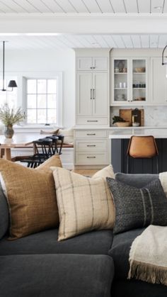 a living room filled with furniture next to a kitchen and dining room table in the background