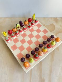 a checkered board with fruits and vegetables on it, sitting on a table top