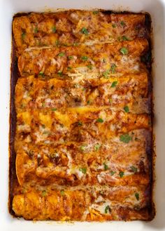 a casserole dish with meat, cheese and parsley in it on a white surface