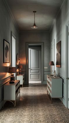 an empty hallway with two lamps on either side of the door and a dresser in front of it