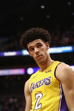 a man in a lakers jersey standing on the court