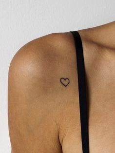 a woman with a small heart tattoo on her shoulder