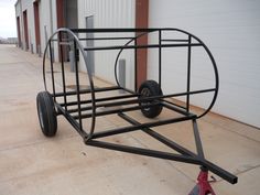 a trailer with wheels is parked in front of a building