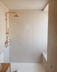 a bathroom with white tile and gold fixtures