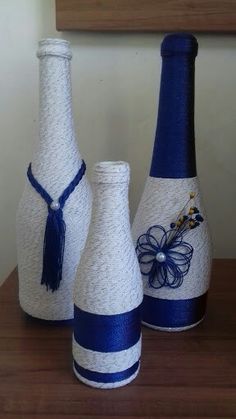 three white and blue vases sitting on top of a wooden table