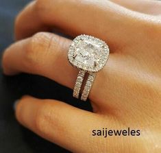 a woman's hand with a diamond ring on top of her finger and an engagement band