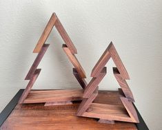 two wooden christmas trees sitting on top of a table