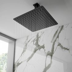 a shower head in the middle of a room with marble walls and flooring on it