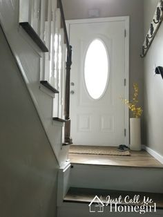 an entryway with stairs leading up to a white door and window above the entrance