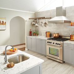 a modern kitchen with stainless steel appliances and marble counter tops is pictured in this image