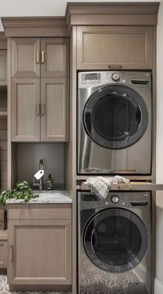 a washer and dryer in a room with wooden cupboards on the wall