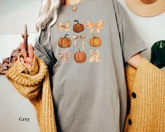 Celebrate this fall season with our coquette style fall bows + pumpkins t-shirt. Click to shop now! 🖤PRODUCT DETAILS: Sizing chart is in the images. Sizes included are unisex S-3XL. - If you would like a t-shirt dress fit, please size up 2-3 sizes. - 100% ring-spun cotton - Medium fabric  - Double-needle stitching throughout the shirt - Relaxed fit 🖤CARE INSTRUCTIONS: Machine wash cold, inside-out with similar colors.  Tumble dry low or hang dry. Avoid using bleach.  🖤HOW TO ORDER: Using the Girly Pumpkin, Fall Coquette, Bow Shirt, Fall Bows, Halloween Graphic, Bow Shirts, Coquette Bow, Vintage Fall, Pumpkin Shirt