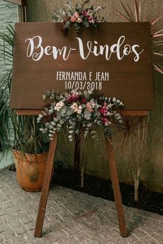 a wooden sign that says ben vindes and has flowers on the top of it