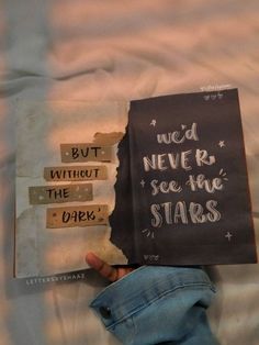 someone is holding up a book with words written on it that read, we'd never see the stars