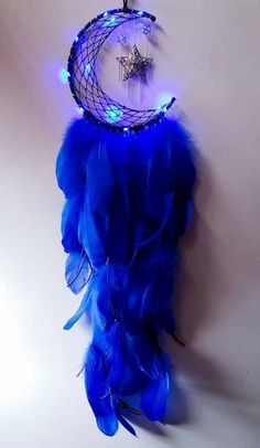 a blue light up dream catcher hanging on the wall next to a star and moon