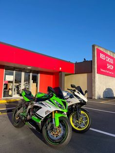 two motorcycles parked in front of a red cross shop