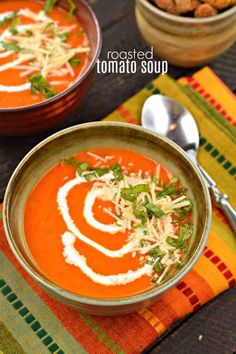 two bowls of tomato soup with parmesan cheese on top and garnish