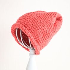 a pink knitted hat sitting on top of a white table