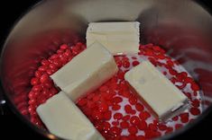 cubes of butter and red candy in a saucepan