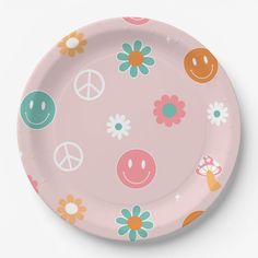 a pink paper plate with flowers and smiley faces on it