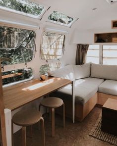 a living area with couch, table and windows