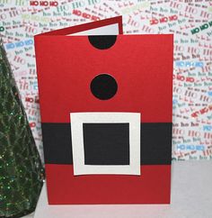 a christmas card with a santa clause on it and a small tree in the background