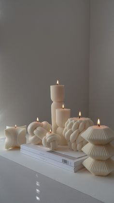 some candles are sitting on top of a book and next to it is a stack of books