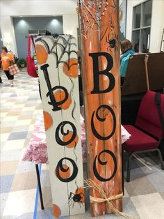 two wooden signs that say booo and halloween are sitting on the floor next to each other