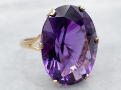 This is a beautiful piece! The ring itself is yellow gold with a simple, minimalist flair. We've set the center with a richly colored, perfectly cut amethyst of the highest quality. This combination of colors and light is outstanding on the hand, and absolutely unique in structure. Metal: 14K Yellow GoldGem: Amethyst 28.20 CaratsGem Measurements: 17.7 x 24.2 mm, OvalRing Size: 7.50Marks: "14K *" Stamped on the inside band The Hand, The Ring, Cocktail Ring, Cocktail Rings, Amethyst, Size 7, Yellow Gold, Band, Ring