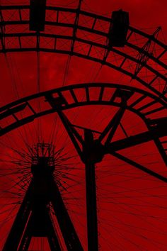 a ferris wheel with red sky in the background