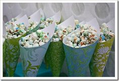 popcorn in green and blue paper cups on a table