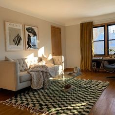 a living room filled with furniture next to a window covered in curtains and rugs