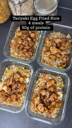 four glass containers filled with food on top of a black table next to some rice