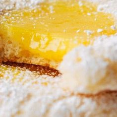 a piece of lemon pie with powdered sugar on the top and one slice missing