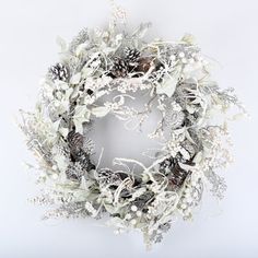 a wreath with white flowers and pine cones