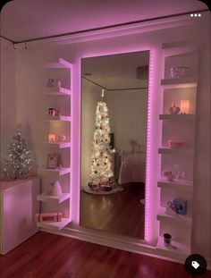 a christmas tree is lit up in the corner of a room with shelves and lights